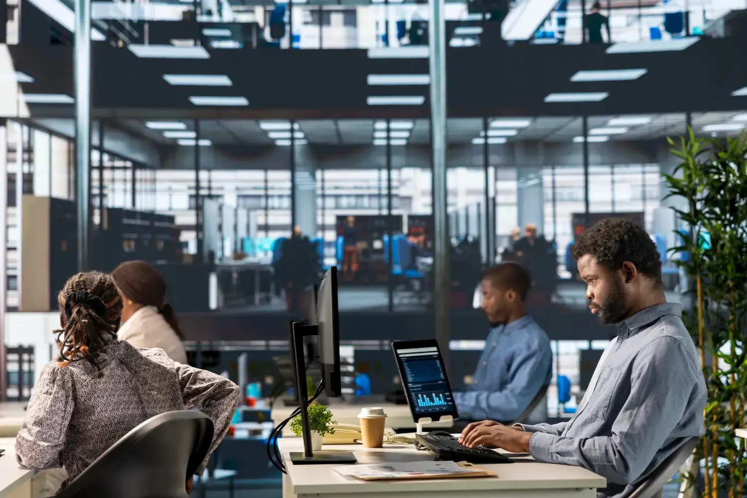 IT professional working on a computer at a modern office floor, illustrating Script All DNA’s scalable and AI powered enterprise IT solutions
