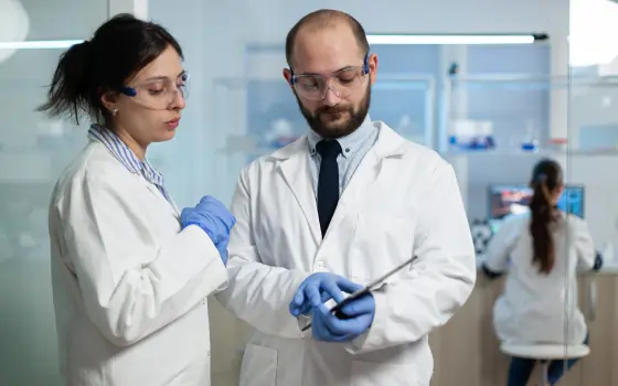 Two scientists reviewing data and discussing results in a laboratory environment.