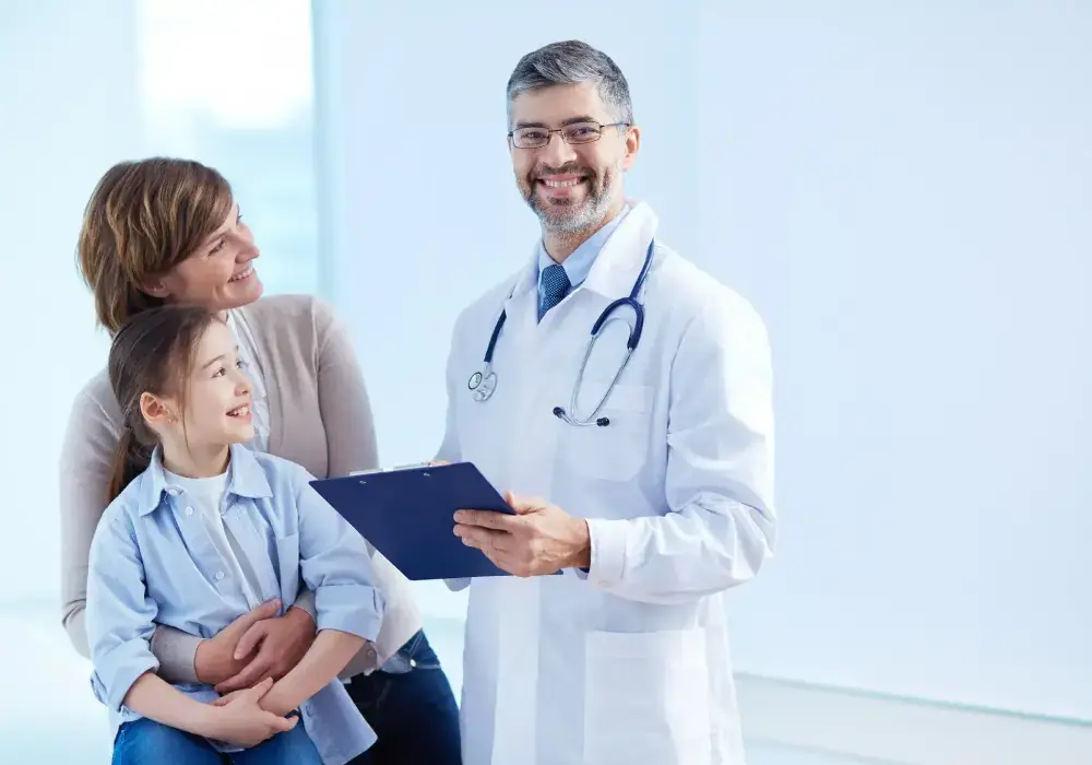 Doctor standing with a family, representing supportive and patient centered healthcare services.