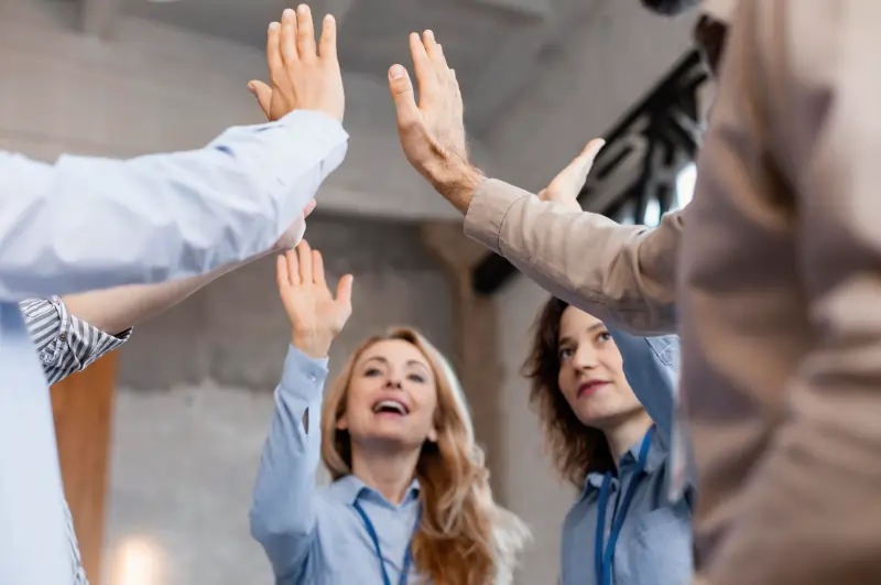 Female cleanroom worker in a green uniform and mask inspecting manufacturing machinery on a production line.